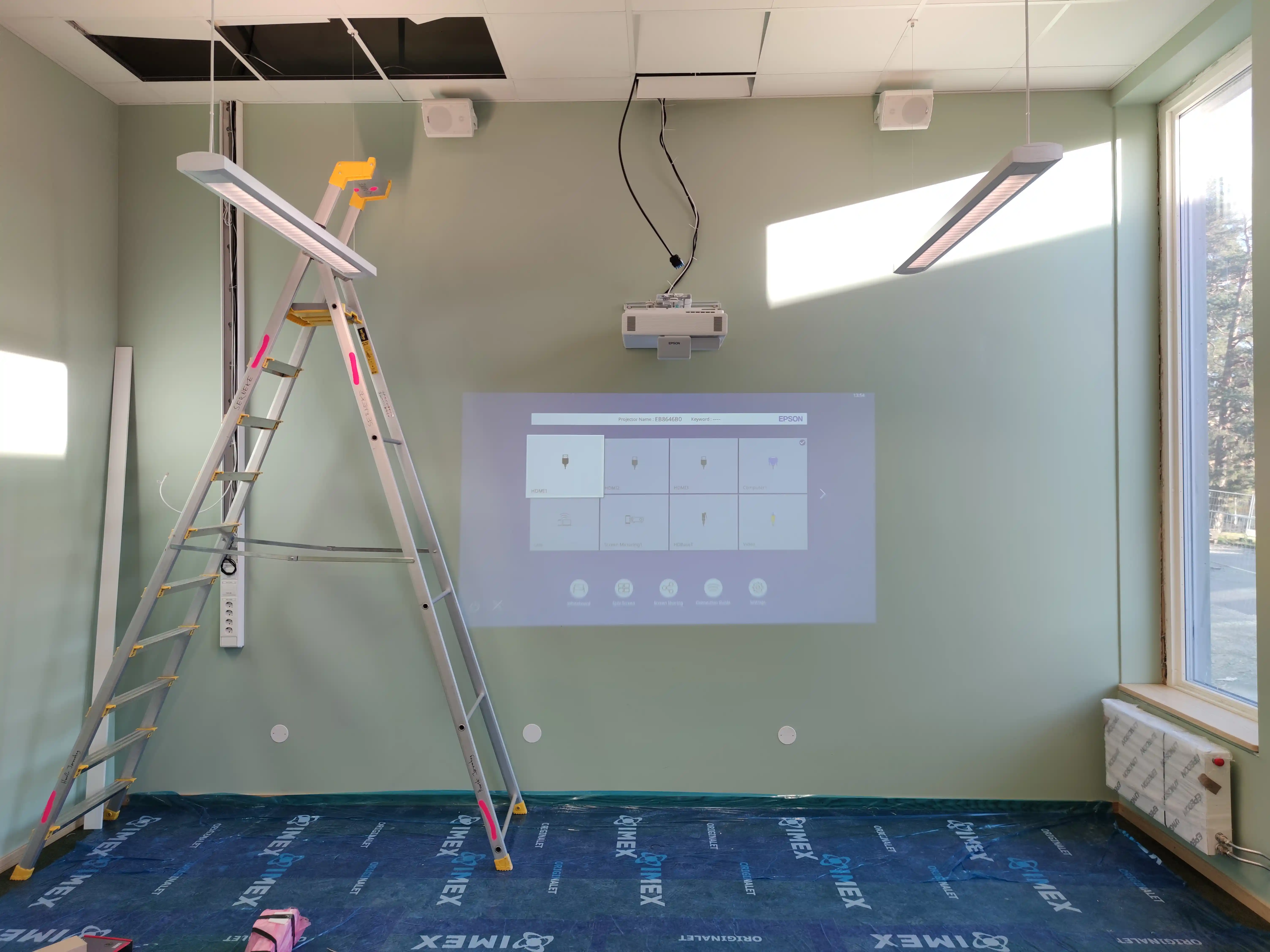 Projektor installeras före whiteboardyta i klassrum på Minnebergsskolan